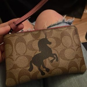 BRAND NEW, NEVER USED. Coach wristlet with unicorn detail on front.